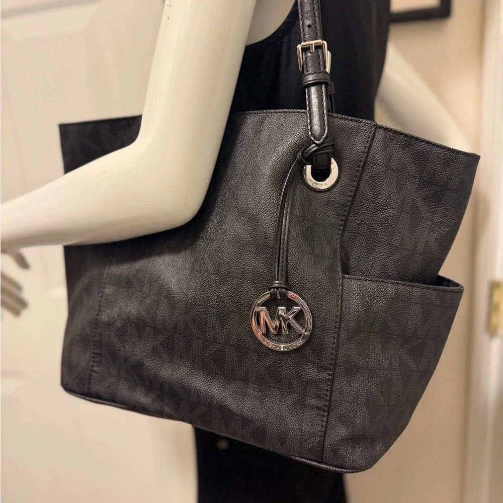 Michael Kors Elegant Black Handbag. Sides packets with a log in the front